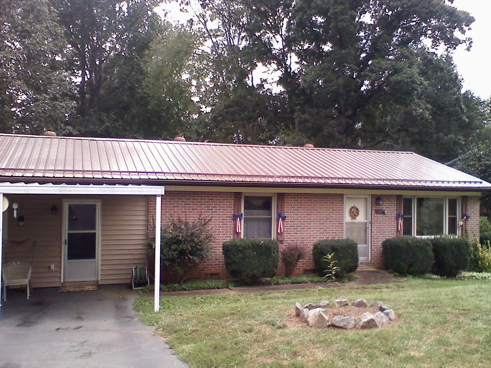 Bronze metal roof and carport on a brick ranch home — Roof Repair work by our crew in Watertown